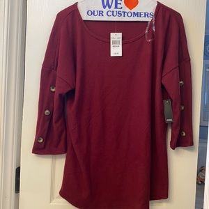 burgundy women’s top with buttons along the sleeves. Never worn ( wrong size)